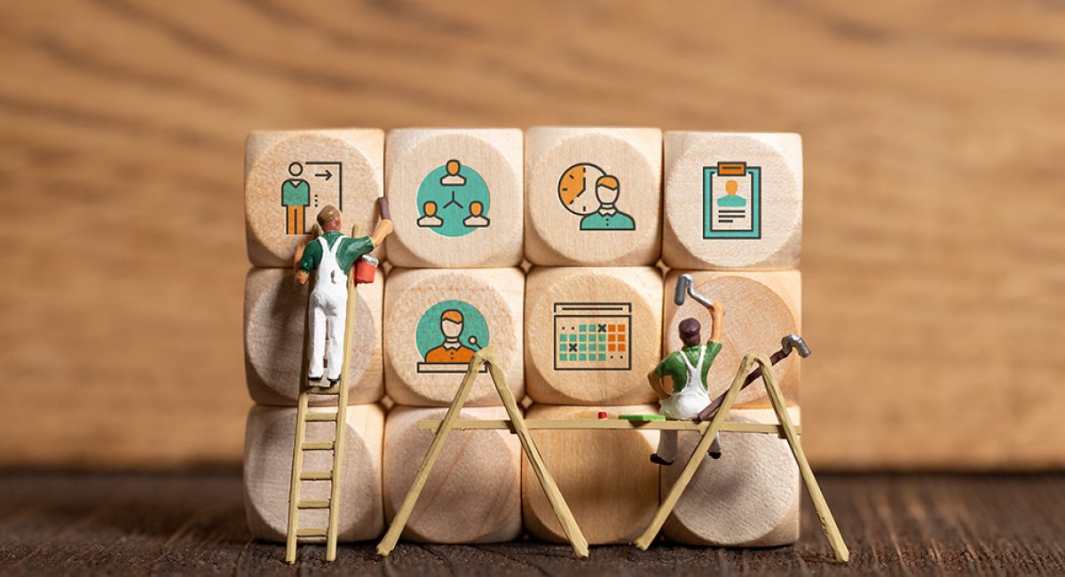 little painter figure and business icons on cubes in front of wo